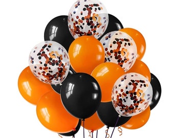 May include: A bunch of orange, black, and clear balloons with confetti inside. The balloons are tied together with black string.