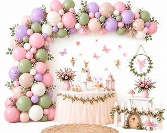 May include: A balloon arch in shades of pink, sage green, lavender, and white, featuring a table with a tulle skirt, a cake, floral arrangements, fairy and butterfly wall decals, a hanging wreath, and a small white picket fence with a door.