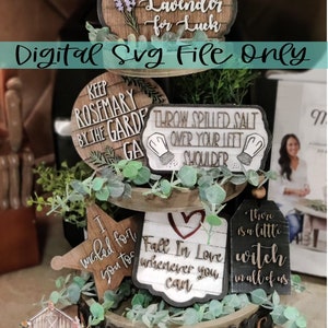 May include: A tiered tray with various wooden signs featuring sayings like "Plant Lavender for Luck", "Keep Rosemary by the Garden", "Throw Spilled Salt Over Your Left Shoulder", "I wiggled for you too", "Fall in Love Wherever You Can", and "There is a little witch in all of us".