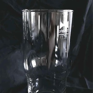 Könnte beinhalten: Ein klares, zylindrisches Glas mit leicht breiterem Boden und schmalerem Oberteil. Das Glas hat eine Kapazitätsmarkierung von 0,3L. Das Glas ist für Getränke konzipiert und eignet sich für den privaten oder gewerblichen Gebrauch.