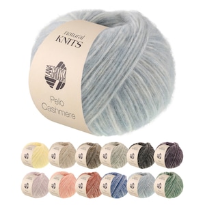 Op de afbeelding: Een bol lichtblauw garen met een beige papieren label met de tekst natural KNITS, LANA GROSSA en Pelo Cashmere. Daaronder twaalf extra bollen garen in diverse kleuren, waaronder geel, beige, bruin, grijs, zwart, paars, roze en groen.