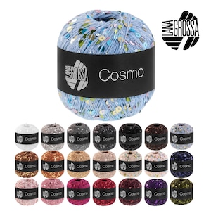 Op de afbeelding: Een collectie Cosmo-garenballen van Lana Grossa. De hoofdband is lichtblauw met pailletten. Het label leest "Cosmo". Extra garenballen in verschillende kleuren worden hieronder weergegeven.