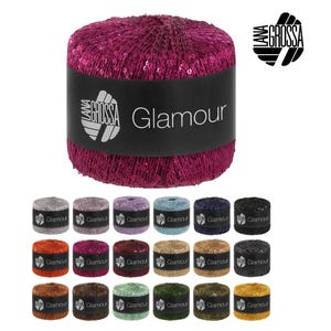 Peut inclure: Gros plan sur une pelote de laine magenta avec le mot "Glamour" sur une étiquette noire. En dessous, plusieurs petites pelotes de différentes couleurs, dont argent, bleu et or. Le logo de la marque est en haut à droite.