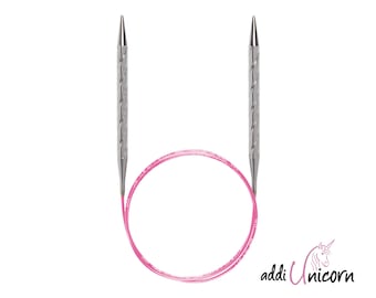 May include: A pair of silver knitting needles with a pink cord. The needles are twisted and have pointed tips. The cord is a bright pink color. The needles are labeled "addi Unicorn".
