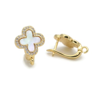 May include: Gold tone earrings with a white mother of pearl clover design and clear cubic zirconia stones.