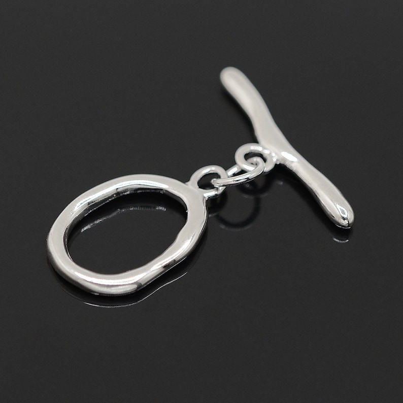 May include: Silver toggle clasp with a smooth, oval ring and a straight bar. The clasp is designed for jewelry making.