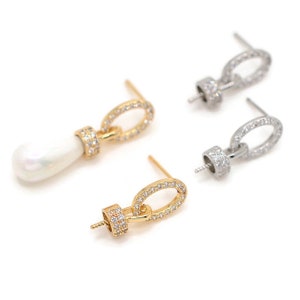May include: Three gold and silver earring findings with a small oval loop and a post. The findings are adorned with clear sparkling stones.