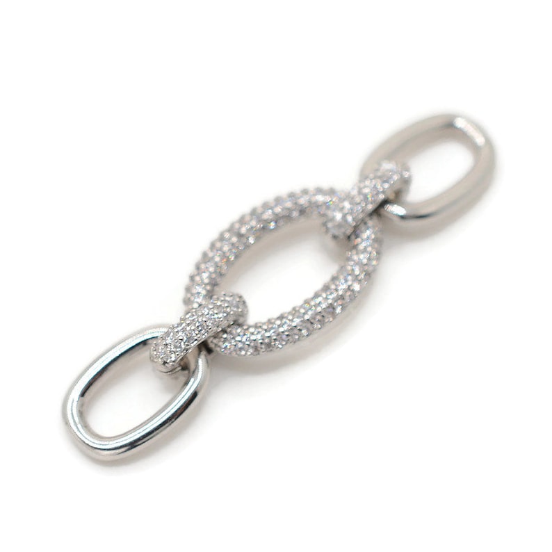 Pode incluir: Um elo de corrente de prata com um design de diamantes pav&eacute;. O elo de corrente tem formato oval e um acabamento polido.