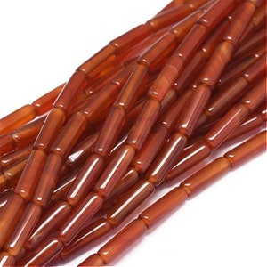 Peut inclure: Un brin de perles de cornaline orange, chaque perle est un cylindre lisse et poli.
