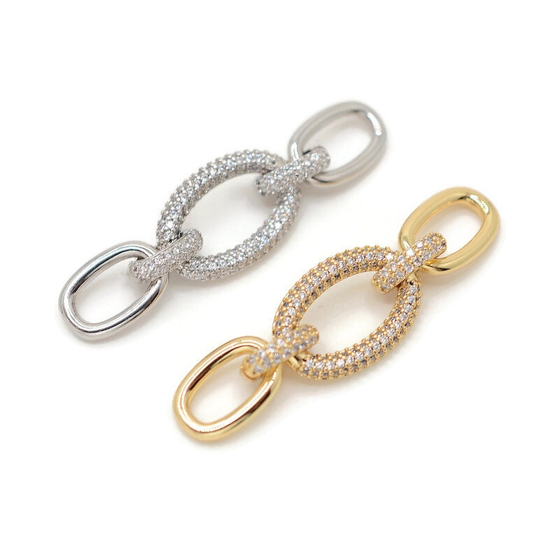 Pode incluir: Dois elos de corrente ovais com um pav&eacute; de pedras de zirc&ocirc;nia c&uacute;bica transparentes. Um elo &eacute; prateado e o outro &eacute; dourado.