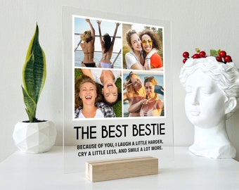Pode incluir: Um porta-retratos de acrílico transparente com uma colagem de quatro fotos de duas mulheres. O porta-retratos tem um suporte de madeira e uma sobreposição de texto preto que diz "THE BEST BESTIE BECAUSE OF YOU, I LAUGH A LITTLE HARDER, CRY A LITTLE LESS, AND SMILE A LOT MORE."