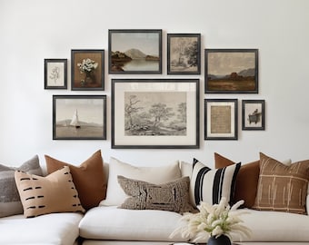 May include: A white sectional sofa with brown and black throw pillows in a living room with a gallery wall of framed landscape prints and a wooden coffee table with a vase of dried flowers.