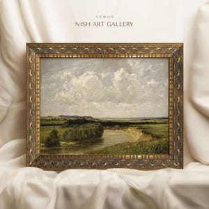 May include: A framed landscape painting depicting a river winding through a green field with a cloudy sky. The frame is ornate and gold in color. The title "VENUS NISH ART GALLERY" is printed at the top of the frame.