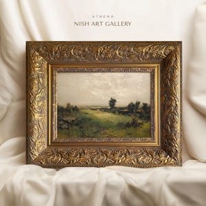May include: A framed landscape painting depicting a rural scene with a grassy field, trees, and a cloudy sky. The frame is ornate and gold in colour.