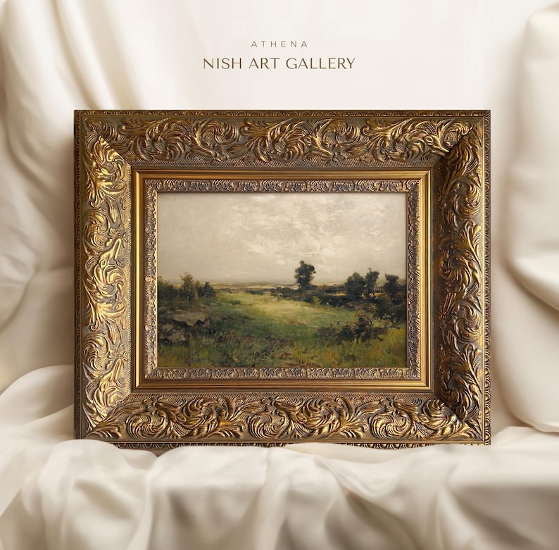 May include: A framed landscape painting depicting a rural scene with a grassy field, trees, and a cloudy sky. The frame is ornate and gold in colour.