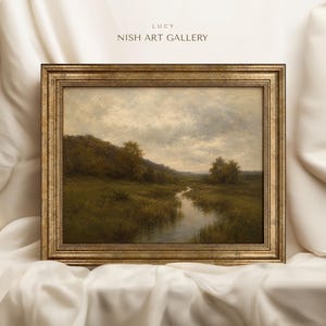Könnte beinhalten: Ein Landschaftsgemälde in einem strukturierten Goldrahmen, das einen gewundenen Bach durch eine grasbewachsene Wiese mit Bäumen und einem bewölkten Himmel zeigt. Der Text LUCY NISH ART GALLERY steht über dem Rahmen.