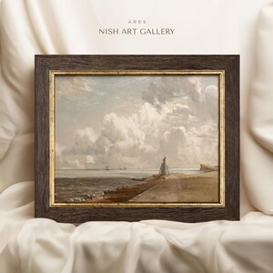 May include: A framed painting depicting a seascape with a lighthouse on a rocky shore. The sky is filled with fluffy white clouds, and the sea is a calm blue. The painting is in a dark brown frame with a gold trim.