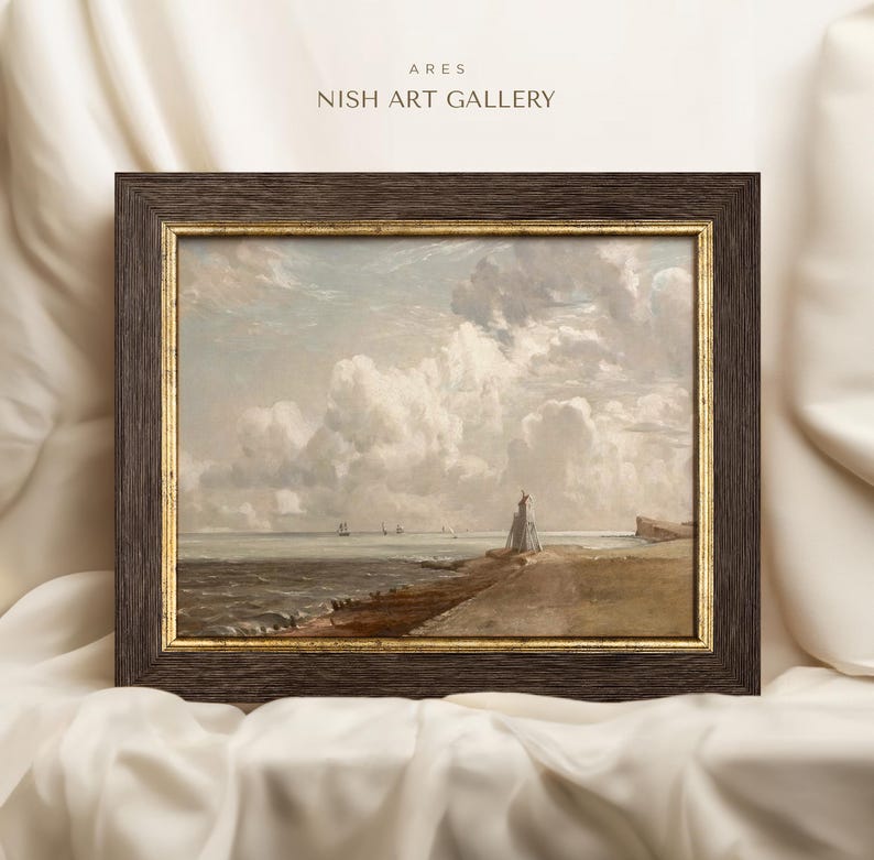 May include: A framed painting depicting a seascape with a lighthouse on a rocky shore. The sky is filled with fluffy white clouds, and the sea is a calm blue. The painting is in a dark brown frame with a gold trim.