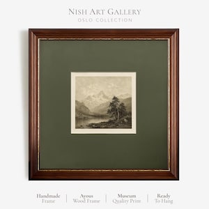 May include: A square framed art print featuring a sepia-toned landscape of mountains, a lake, and trees. The artwork is encased in a dark brown wooden frame with a gold inner trim and a wide olive green mat. Text reads Nish Art Gallery Oslo Collection.