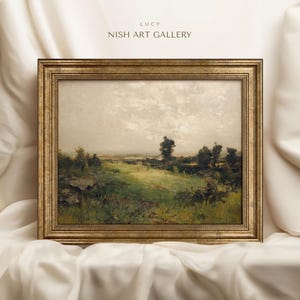 May include: A framed landscape painting depicting a rural scene with a field of green grass, trees, and a cloudy sky. The frame is gold with a decorative border.