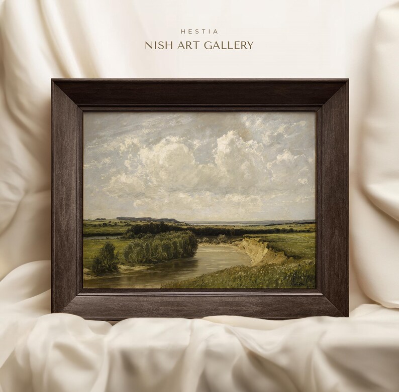May include: A framed painting depicting a landscape with a river winding through a field. The sky is a light blue with fluffy white clouds. The painting is in a dark brown frame.