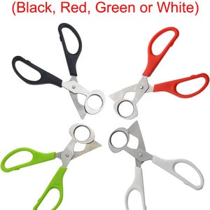 May include: Four pairs of scissors with different colored handles: black, red, green, and white. The scissors have a ring cutter on one blade and are designed for cutting cigars.