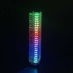 Op de afbeelding: Een toren van gestapelde, heldere acrylvierkanten met ingebouwde LED-verlichting die in een regenboogpatroon oplichten, waardoor een kleurrijk en modern lichtsculptuur ontstaat.