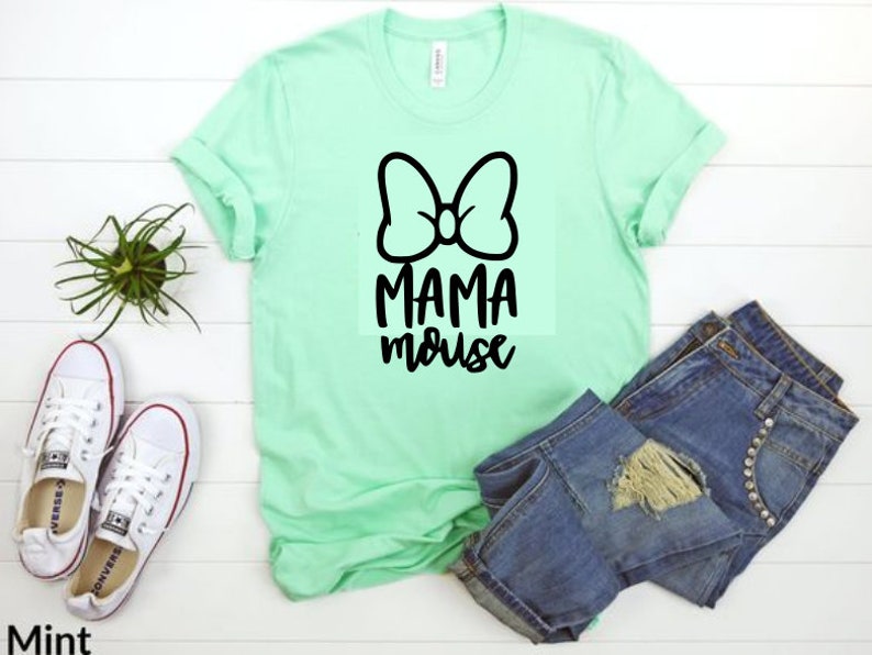 Op de afbeelding: Een mintgroen T-shirt met een zwarte strik en de tekst "Mama Mouse" erop gedrukt.
