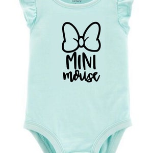 Op de afbeelding: Een lichtblauwe baby romper met een zwarte strik en de tekst "MINI mouse" gedrukt op de voorkant.