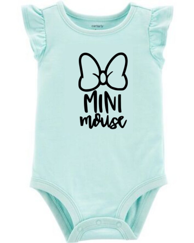 Op de afbeelding: Een lichtblauwe baby romper met een zwarte strik en de tekst "MINI mouse" gedrukt op de voorkant.