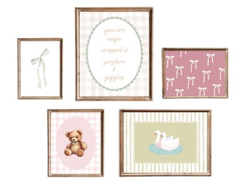 May include: A collection of five framed art prints with a nursery theme. The prints feature a watercolor bow, a teddy bear, swans, and text that reads "you are magic wrapped in sunshine & giggles." The frames are wood.