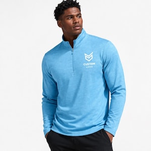 May include: A light blue long-sleeve pullover with a quarter-zip neckline. The shirt features a white logo with the text "CUSTOM LOGO" on the upper left chest. The model is wearing black pants.