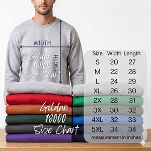 A man is standing next to a stack of colorful t-shirts, with a size chart displayed next to him.