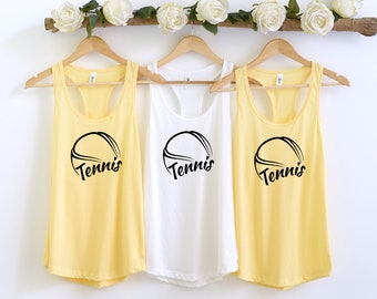 May include: Three yellow tank tops with a black tennis ball graphic and the word "Tennis" printed on the front.