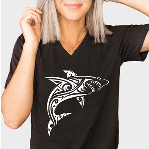 May include: Black t-shirt with a white tribal shark design.