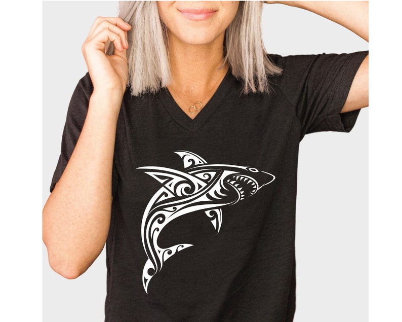 May include: Black t-shirt with a white tribal shark design.