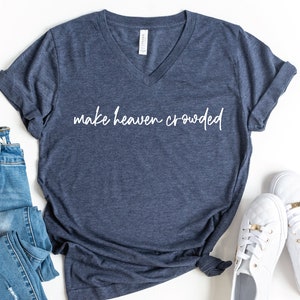 May include: A navy blue v-neck t-shirt with the text "make heaven crowded" in white lettering.