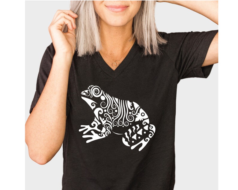 May include: A black v-neck t-shirt with a white stylized design of a frog with intricate details.