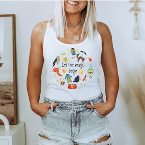 May include: White tank top with a colorful graphic of various magical objects and the text "Let the magic begin".