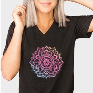 May include: A black v-neck t-shirt with a colorful mandala design printed on the front. The mandala is a circular design with intricate details and a gradient of pink, orange, yellow, and blue.