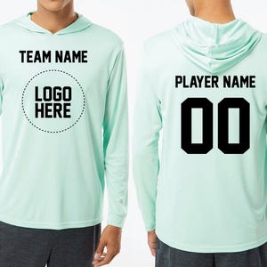 a man wearing a light green hoodie with a logo on it