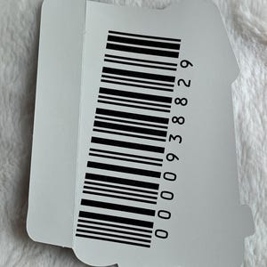 May include: A white sticker with a black barcode and the number 000938829 printed on it.