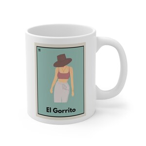 May include: White ceramic mug with a colorful illustration of a person wearing a hat and the text "El Gorrito" on a light blue background.