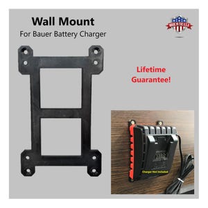 May include: Black wall mount for a Bauer battery charger. The mount has a rectangular design with two square openings and four mounting holes. The text "Wall Mount For Bauer Battery Charger" is visible. The image also includes a charger mounted on a wooden surface.