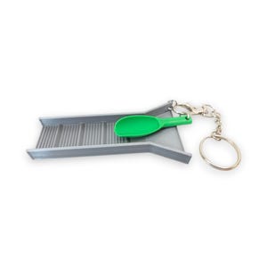 May include: A miniature gray gold pan with a green scoop, attached to a keychain. The gold pan has a ridged surface. The scoop is bright green. The keychain has a silver clasp and a silver ring.