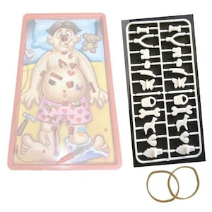 May include: A children's game featuring a cartoon patient with various ailments. The game includes a plastic tray, a set of plastic game pieces, and two rubber bands. The patient is lying on a bed, and the game pieces are designed to fit into the patient's body.