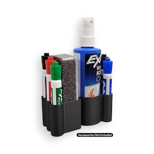 May include: Black plastic whiteboard accessory organizer holding markers, a cleaning spray bottle, and an eraser. The organizer has multiple compartments to hold the supplies. The spray bottle is blue with white text. The text "Accessories Not Included" is at the bottom.