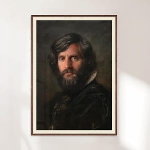 May include: A framed portrait of a man with long, dark hair and a full beard. The man is wearing a dark velvet jacket with a high collar. The portrait is in a dark wooden frame, and the background is a muted, dark color.