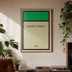 May include: A framed art print featuring a green and cream color block design with the words "BAKER STREET" and the year "1978". The print is in a wooden frame and hangs on a wall. The room has plants and a stereo system.