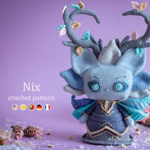 Op de afbeelding: Een gehaakt blauw en paars wezen met gewei en vleugels. Het wezen heeft grote, helderblauwe ogen en draagt een blauwe en gouden jurk. De tekst "Nix crochet pattern" staat onder het wezen.